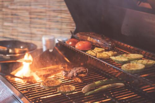 a grill with meat and vegetables and food on it at Ruta Verde BB in Tambor