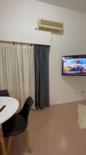 a room with a table and a tv on a wall at Vista Parque! StayPark - 2 cama 2 personas Saavedra in Buenos Aires