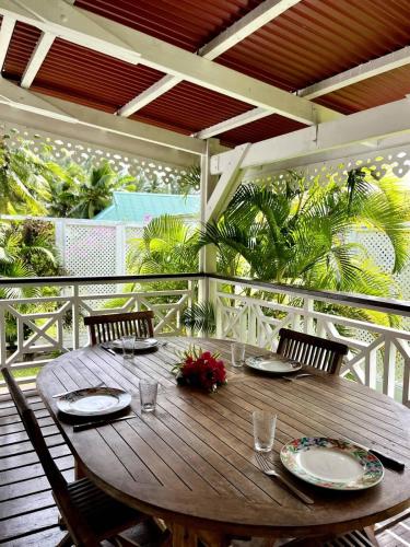 a wooden table on a porch with chairs and a tableablish at Fare Torehau Tiahura in Hauru