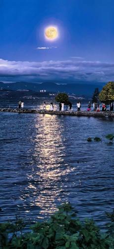 a large body of water at night with a full moon at Erhaike Seaview Inn in Dali