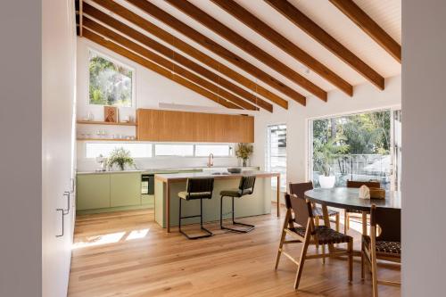 a kitchen and dining room with a table and chairs at Blackbutt House - Luxe Retreat With Pool and Sauna in Suffolk Park