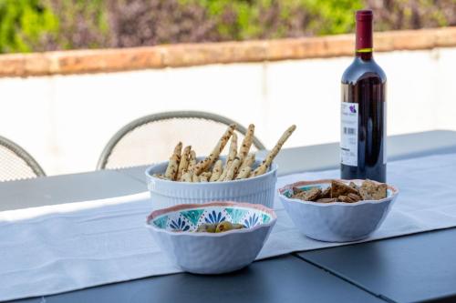 a table with two bowls of food and a bottle of wine at Italian Experience- Poggio Padule in San Venanzo