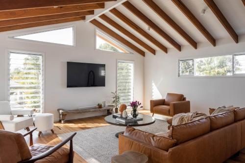 a living room with a couch and a table at Blackbutt House - Luxe Retreat With Pool and Sauna in Suffolk Park