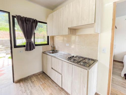 a kitchen with a sink and a stove at Best View Aparta Hotel in Dosquebradas