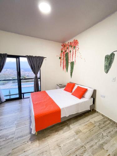 a bedroom with a bed with orange and white sheets at Best View Aparta Hotel in Dosquebradas