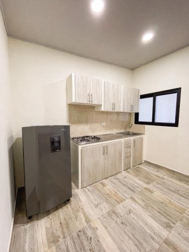 a kitchen with a stainless steel refrigerator and wooden floors at Best View Aparta Hotel in Dosquebradas