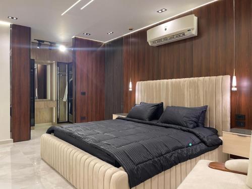 a bedroom with a large bed with a black blanket at Brand New Apartment Obour City in Obour