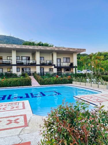 a hotel with a swimming pool in front of a building at Best View Aparta Hotel in Dosquebradas