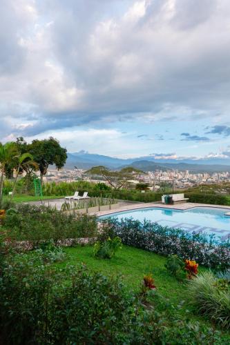 a swimming pool with a city in the background at Best View Aparta Hotel in Dosquebradas