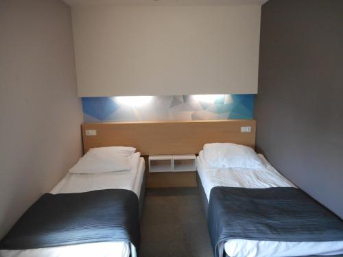two beds in a small room with at Hotel Platan in Ostrów Wielkopolski