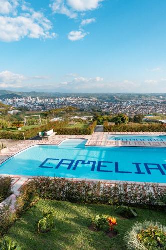 a large swimming pool with a city in the background at Best View Aparta Hotel in Dosquebradas