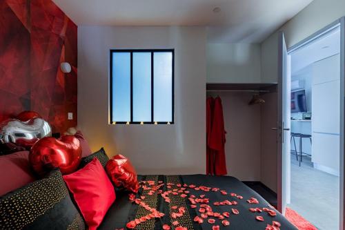 サン・テティエンヌにあるBeige Hospitalité - Ruby - Love Room - Netflixのベッドルーム1室(赤い枕のベッド1台、窓付)