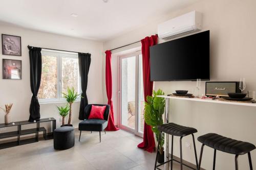 uma sala de estar com cortinas vermelhas e uma televisão em Ruby - 4 pers - Netflix em Saint-Étienne
