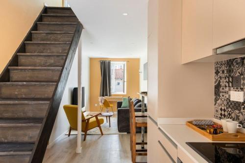 a kitchen with a staircase and a living room at Beige Hospitalité - Agathe - Le nid Urbain in Saint-Étienne