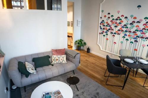 a living room with a couch and a table at Beige Hospitalité - Emma - hypercentre - appart' unique-parking in Saint-Étienne