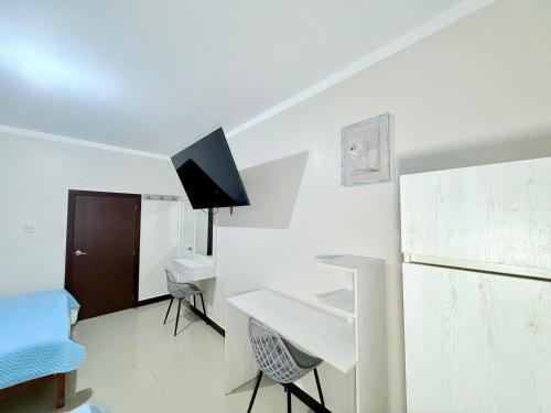 a white room with a desk and a tv at Hotel SMIR, Huaquillas in Huaquillas