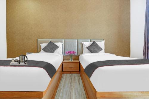 two beds in a room with white and black at Townhouse Ekana Inn in Vibhuti Khand