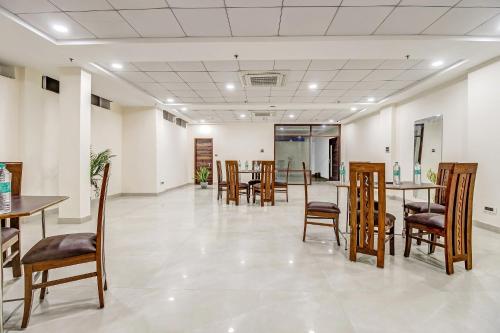 a waiting room with tables and chairs in a building at Townhouse Ekana Inn in Vibhuti Khand