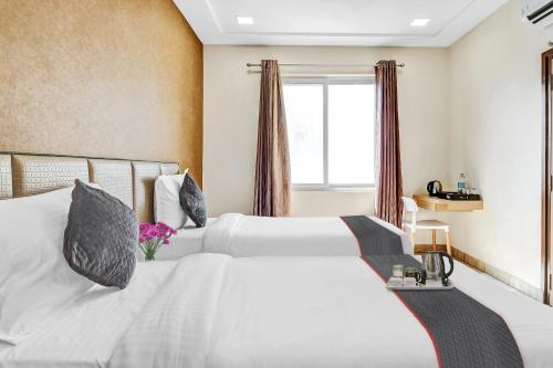 a bedroom with two white beds and a window at Townhouse Ekana Inn in Vibhuti Khand