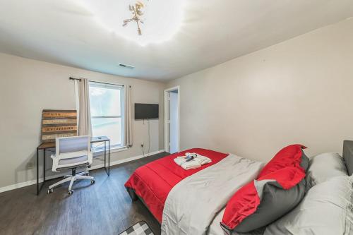 a bedroom with a bed with a red blanket and a desk at Lux Stay - 3mins to UC Medical & DT Cincinnati in Cincinnati