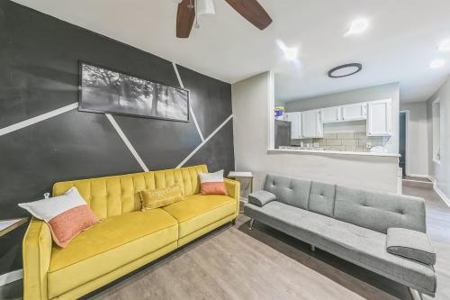 a living room with a yellow couch and a couch and a kitchen at Lux Stay - 3mins to UC Medical & DT Cincinnati in Cincinnati