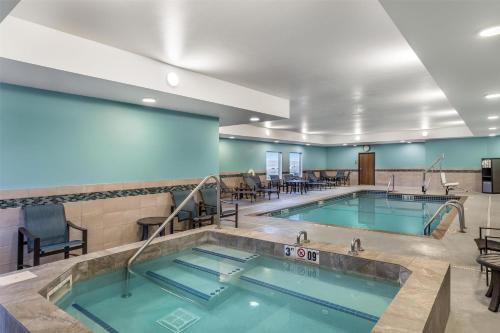 a swimming pool with tables and chairs in a building at Best Western Plus Rapid City Rushmore in Rapid City