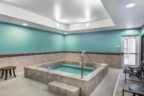 a large tub in a room with blue walls at Best Western Plus Rapid City Rushmore in Rapid City