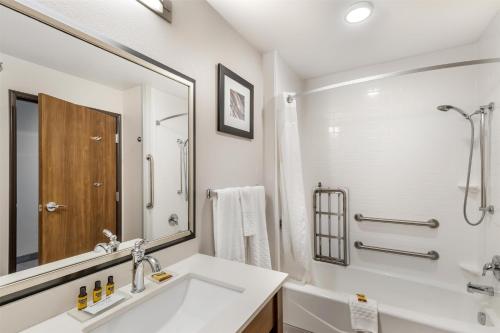 a white bathroom with a sink and a mirror at Best Western Plus Rapid City Rushmore in Rapid City