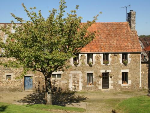an old stone building with a tree in front of it at Normandy Countryside Stay in Montaigu-les-Bois