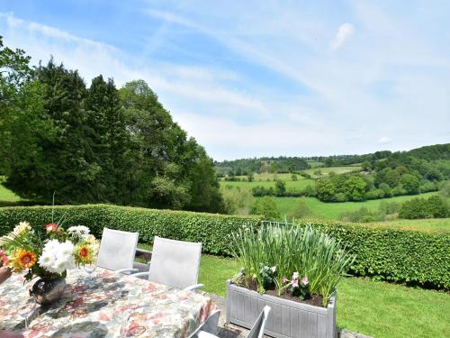 a table with chairs and flowers on top of a field at Normandy Countryside Stay in Montaigu-les-Bois