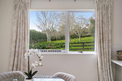 a window with a view of a garden from a table at Luxe Country Escape in Ramarama
