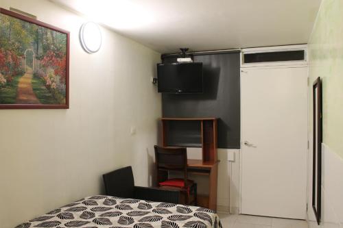 a bedroom with a bed and a tv on the wall at Casa Posada Amelia in Bogotá