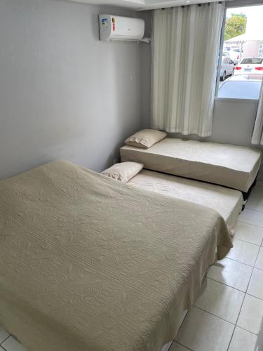 two beds sitting next to each other in a room at Apartamento condomínio Ônix in Campos dos Goytacazes
