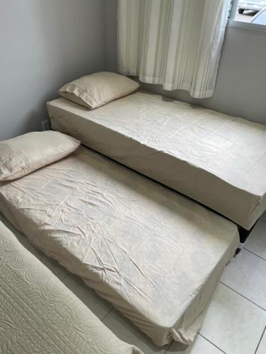 two beds sitting next to each other in a room at Apartamento condomínio Ônix in Campos dos Goytacazes