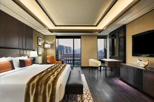 a hotel room with a bed and a flat screen tv at Bellagio by MGM Shanghai - on the bund in Shanghai