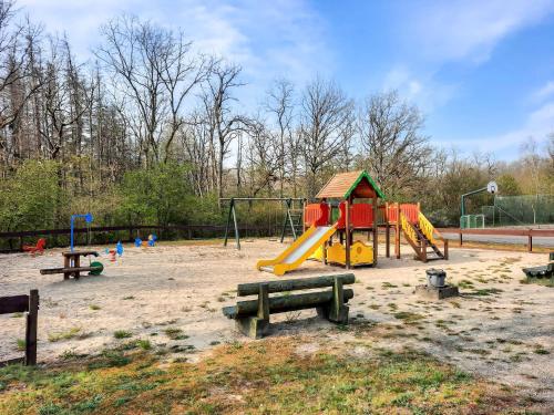 a park with a playground with a slide and benches at Cosy chalet near Durbuy in nature in Somme-Leuze