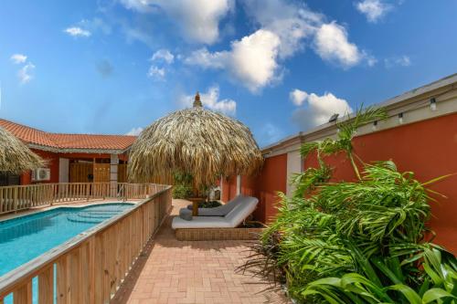 a resort with a swimming pool next to a building at Moderne Studio Sea dichtbij de zee met zwembad in Oranjestad