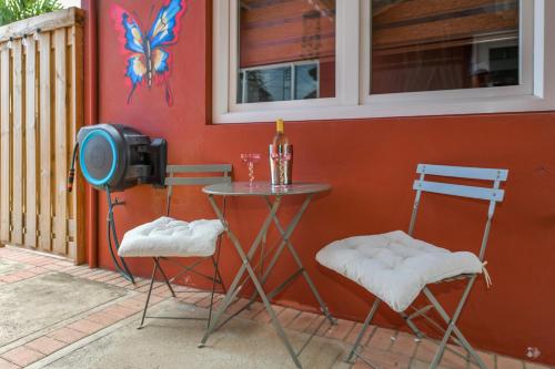 a table and two chairs next to a wall with a tv at Moderne studio Sun dichtbij de zee met zwembad in Oranjestad