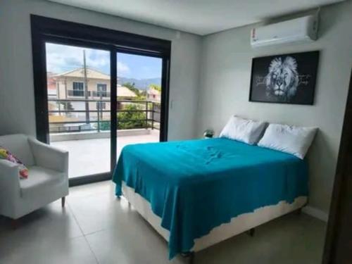 a bedroom with a bed and a chair and a window at Hotel Amarilla in Caviahue