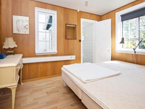 a bedroom with a bed and a desk and windows at 4 person holiday home in Odder-By Traum in Odder