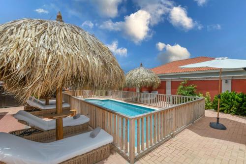 a resort with a swimming pool and a resort at Moderne studio Sun dichtbij de zee met zwembad in Oranjestad