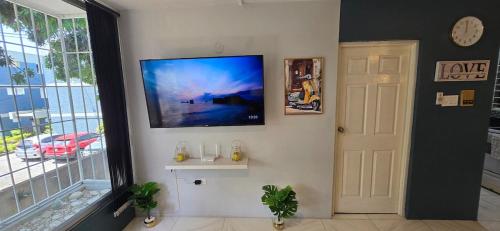 a living room with a flat screen tv on a wall at The Central Comfort in Kingston