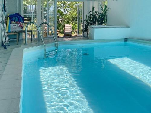 a large blue swimming pool in a house at Tranquil Oasis with Pool - By Traum Ferienwohnungen in Ørsted