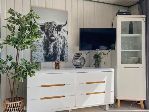 a white dresser with a picture of a bull at Tranquil Oasis with Pool - By Traum Ferienwohnungen in Ørsted