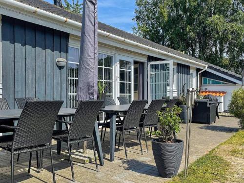 a table and chairs sitting in front of a house at Tranquil Oasis with Pool - By Traum Ferienwohnungen in Ørsted