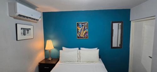 a blue bedroom with a bed and a blue wall at The Central Comfort in Kingston