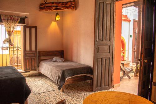 a bedroom with a bed and an open door at Casa Tequio in San Cristóbal de Las Casas