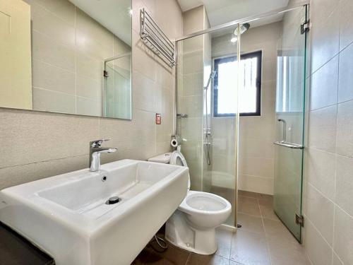 a white bathroom with a sink and a toilet at Atlantis Residences Melaka in Melaka