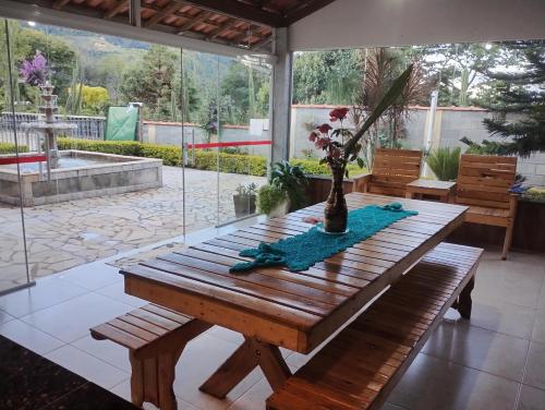 a wooden table with a vase on it on a patio at Sítio Bela Vista in Cristina