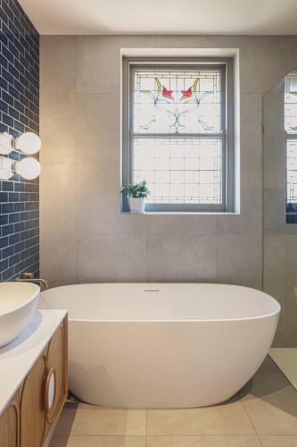 a bathroom with a tub and a sink and a window at Family Luxury In Lake Wendouree in Wendouree